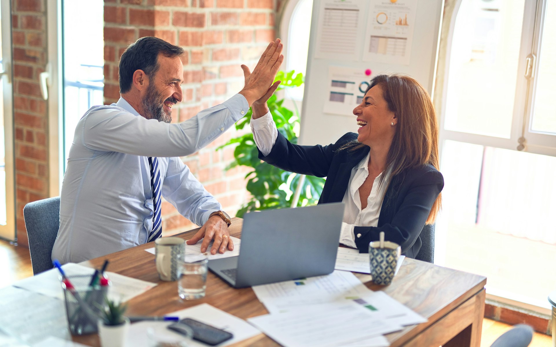 man and woman discussing work at desk
