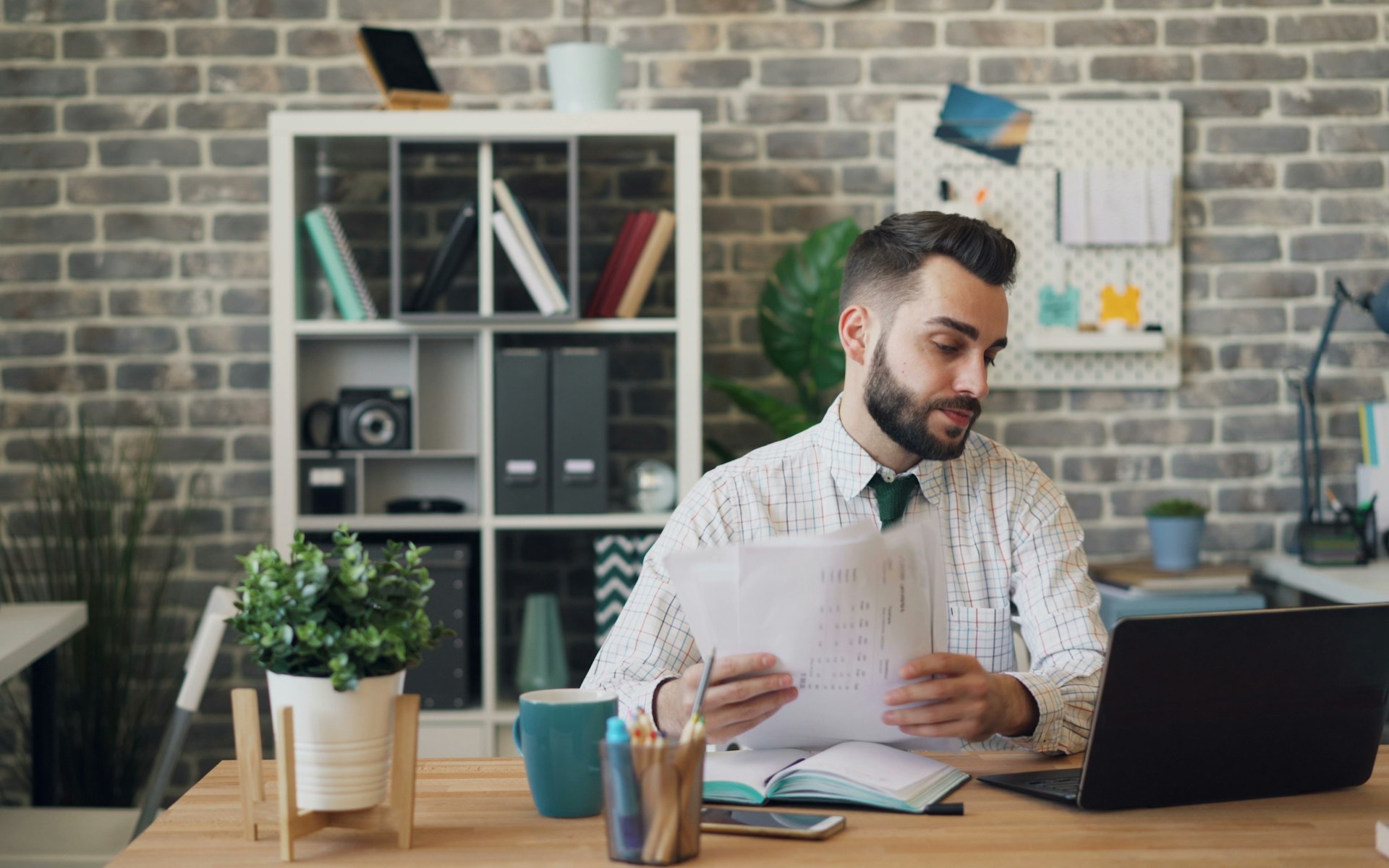 a man sitting at a desk with a laptop and papers