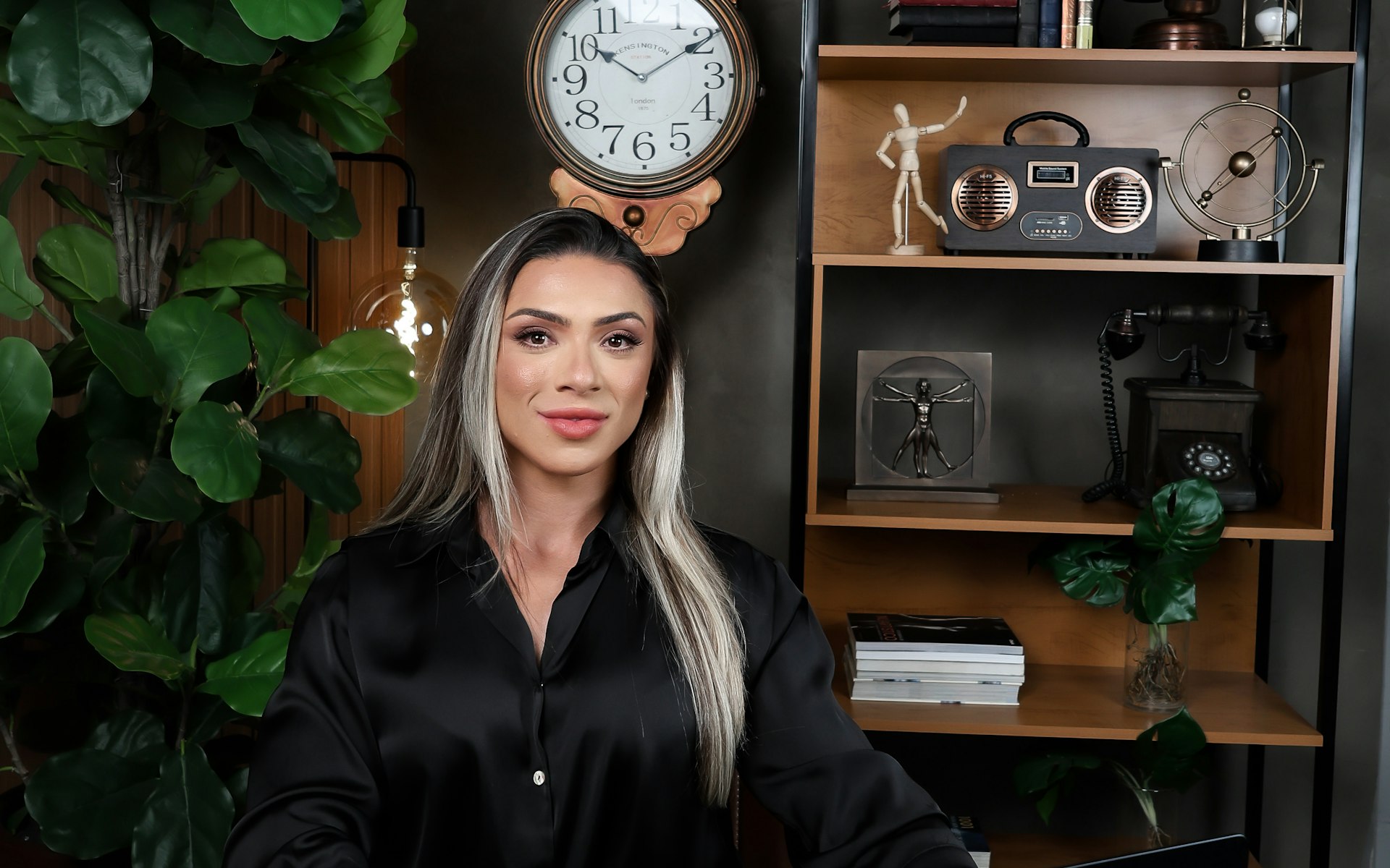 Woman in black shirt working on laptop at desk